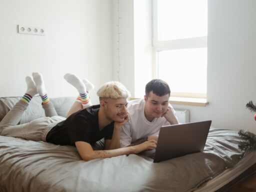 a couple using a laptop on a bed