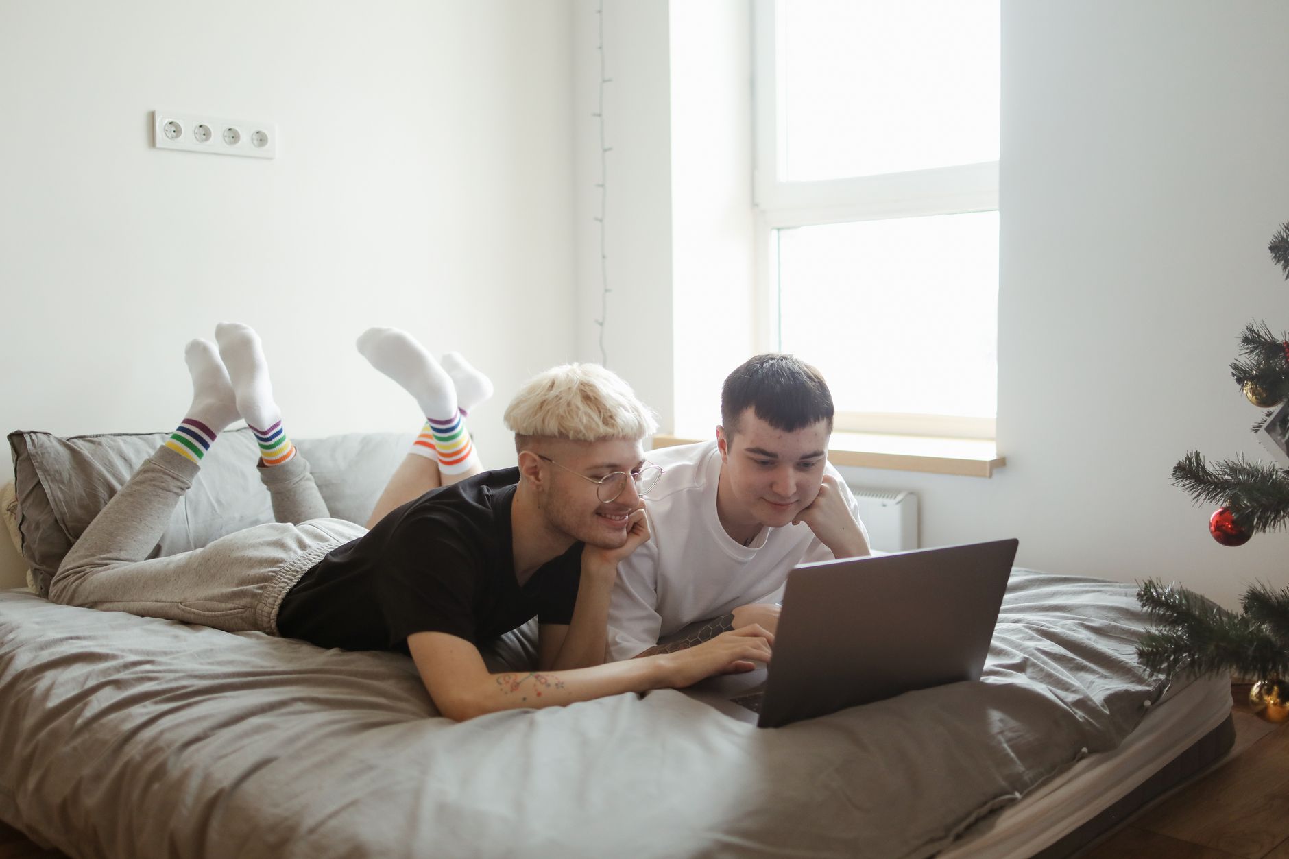 a couple using a laptop on a bed